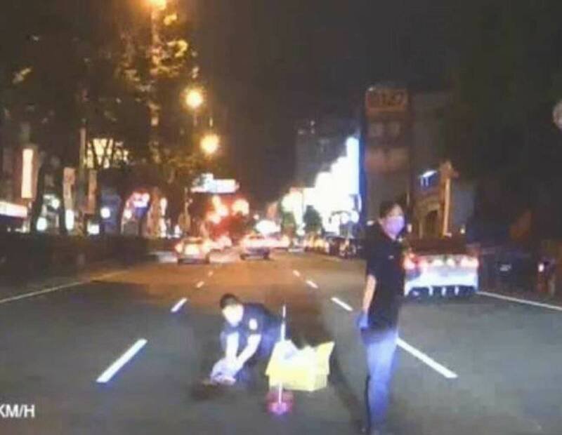 员警将受伤的流浪猫装入纸箱。(图由警方提供) 员警将受伤的流浪猫装入纸箱。(图由警方提供)