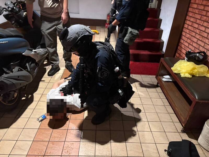警方在汽旅内将犯嫌压制在地。(记者徐圣伦翻摄) 警方在汽旅内将犯嫌压制在地。(记者徐圣伦翻摄)