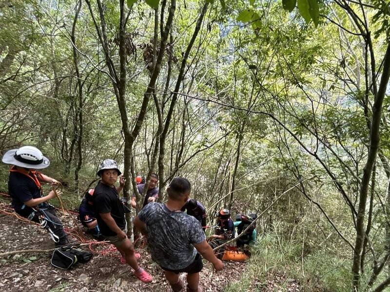 玉山八通关高山协作不慎坠落50公尺深谷,搜救人员以绳索搭配担架,缓步拉上步道后紧急送医治疗。(南投县消防局提供) 玉山八通关高山协作不慎坠落50公尺深谷,搜救人员以绳索搭配担架,缓步拉上步道后紧急送医治疗。(南投县消防局提供)