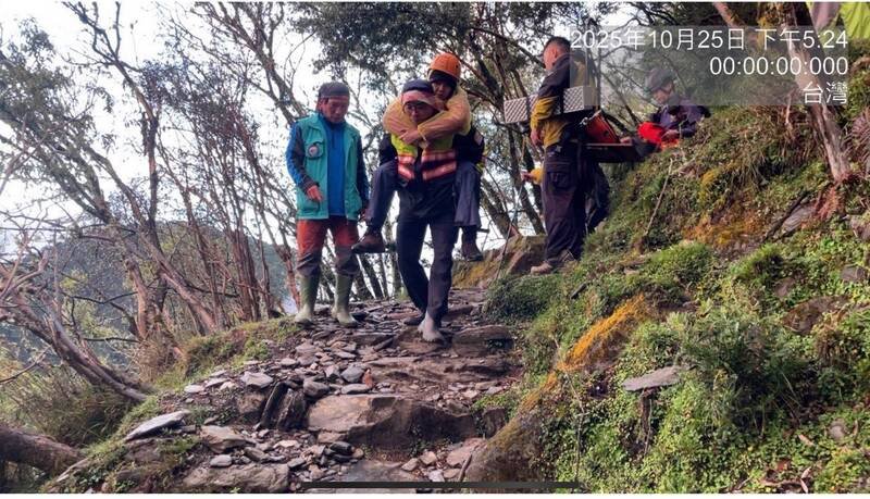 警消人员接力将彭女从玉山登山步道背负下山。(图由警方提供) 警消人员接力将彭女从玉山登山步道背负下山。(图由警方提供)