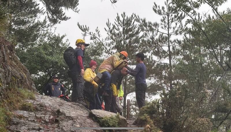 彭女因高山症发作,由警消人员背负下山。(图由警方提供) 彭女因高山症发作,由警消人员背负下山。(图由警方提供)