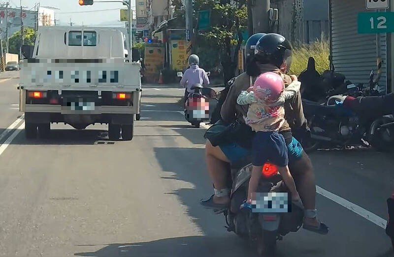 1辆4贴机车行驶在路上，妈妈后方揹著1名幼童双脚悬空挂著，相当危险。（撷取自Wowtchout – 地图型行车纪录器分享平台）