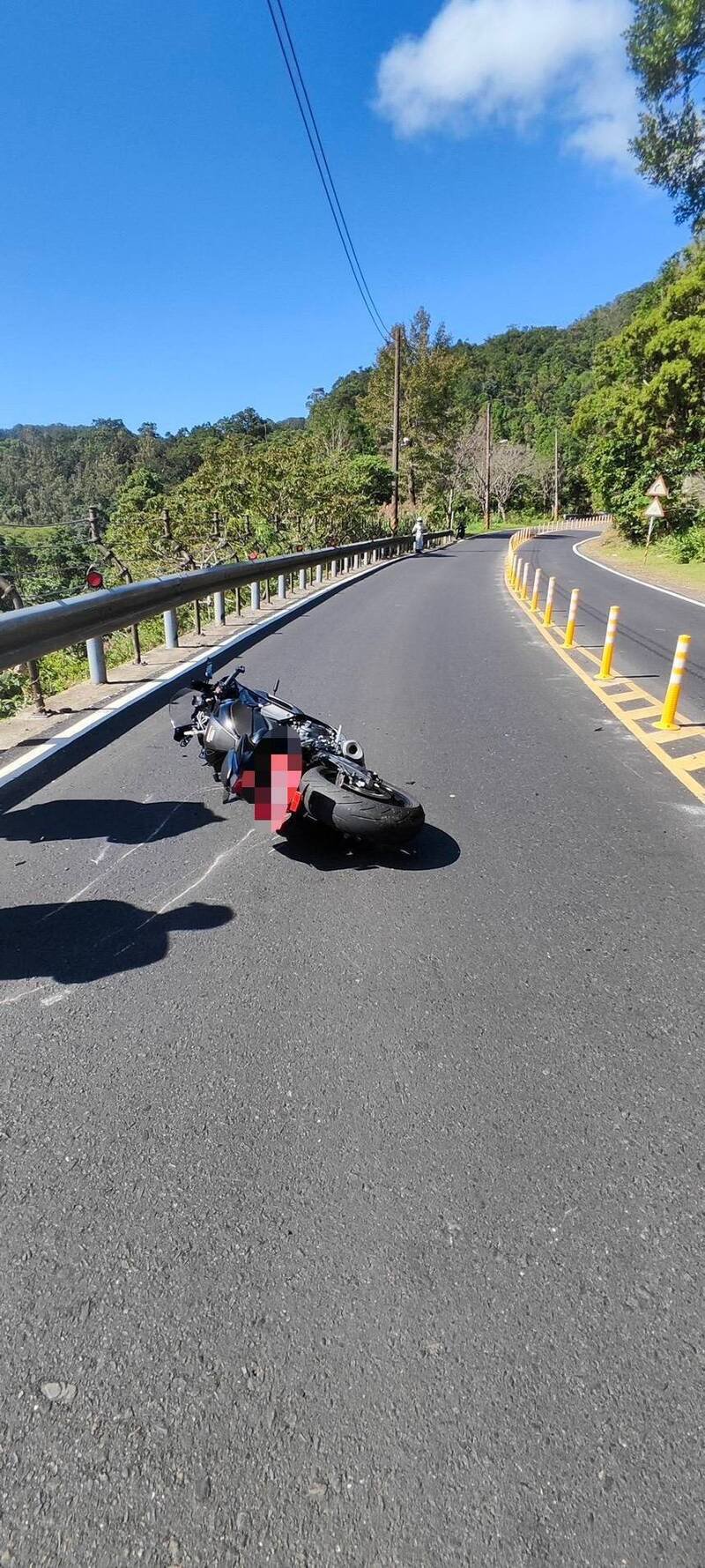 林男骑乘大型重机行经新北市石碇区北宜公路28.4公里处时，疑因过弯不慎冲到对向车道，撞击护栏后摔落5公尺山坡。（记者陆运锋翻摄）