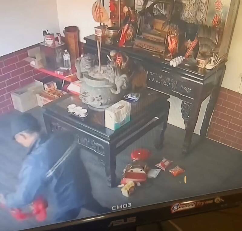 监视画面可见男子爬到神桌上将神明扯到地面，再偷走金牌。（民众提供）