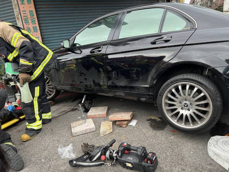 戴姓骑士受伤倒地后被压在车子底下，救护人员使用千斤顶才将戴姓机车骑士救出，但戴已经没有生命现象。（警方提供）