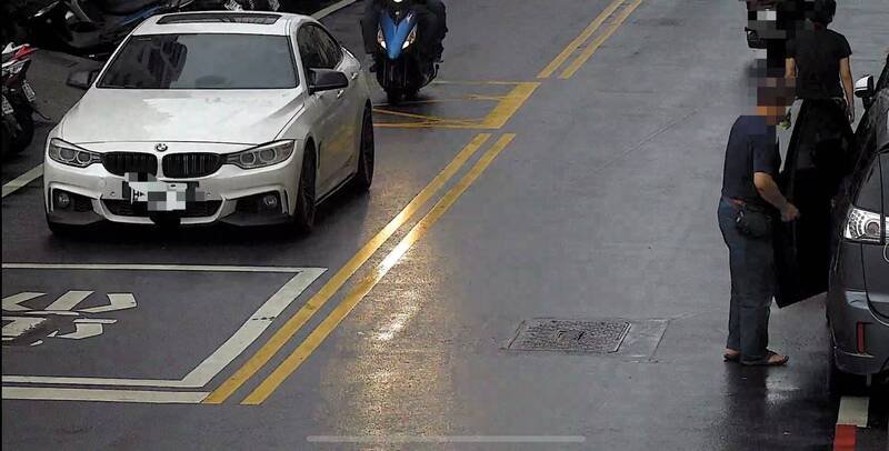 吴男驾驶白色BMW轿车，在银行对面马路监控陈姓兄弟面交收款过程。（记者陈冠备翻摄）