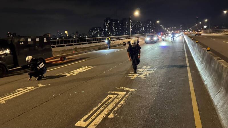 运钞车在板桥浮洲桥上掉落一袋零钱，保全员冒险摸黑捡拾，沙仑所警员警见状，协助封路、捡拾（见图）。（记者吴仁捷翻摄）