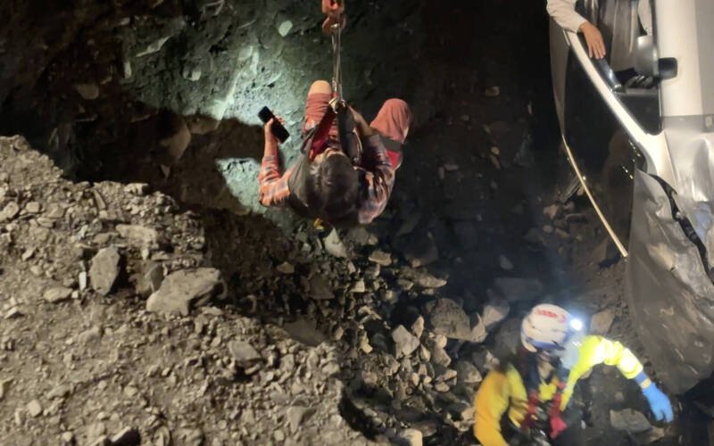 救难人员将2人吊挂至路面。（民众提供）