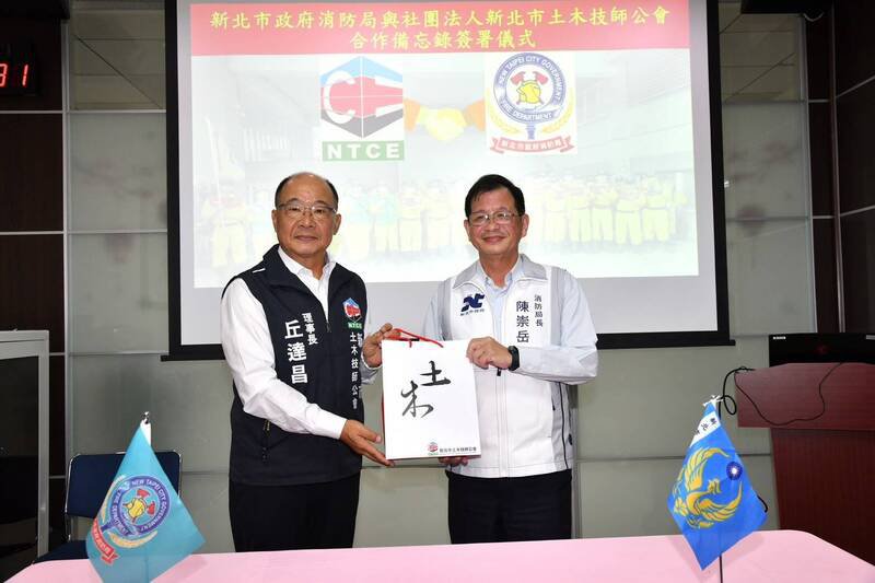 新北市消防局今天与新北市土木技师公会签署合作备忘录（MOU），消防局长陈崇岳（右）与土木技师公会理事长丘达昌（左）共同签署。（记者吴仁捷翻摄）