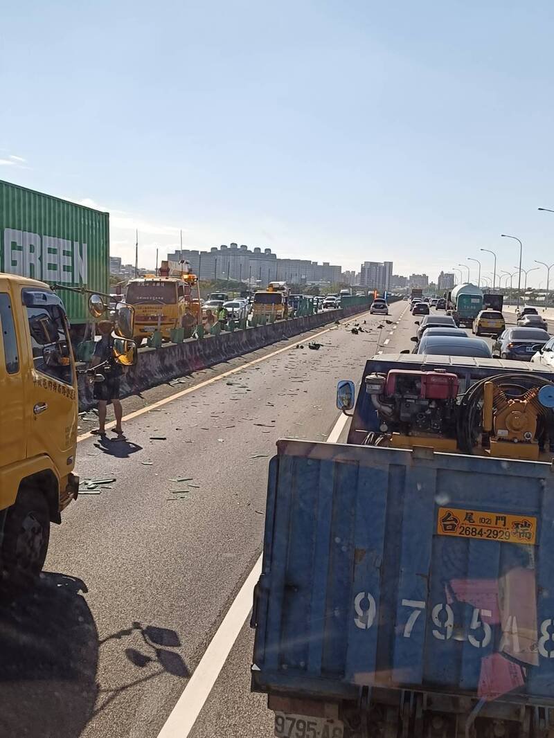 长荣货柜车行经国1中坜路段爆胎擦撞轿车、内侧护栏，双向后方回堵约5公里。（民众提供）