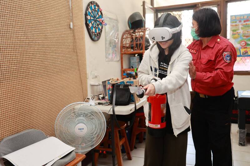南投县消防局进行防火宣导，提供「虚拟实境灭火器」让民众体验。（南投县消防局提供）