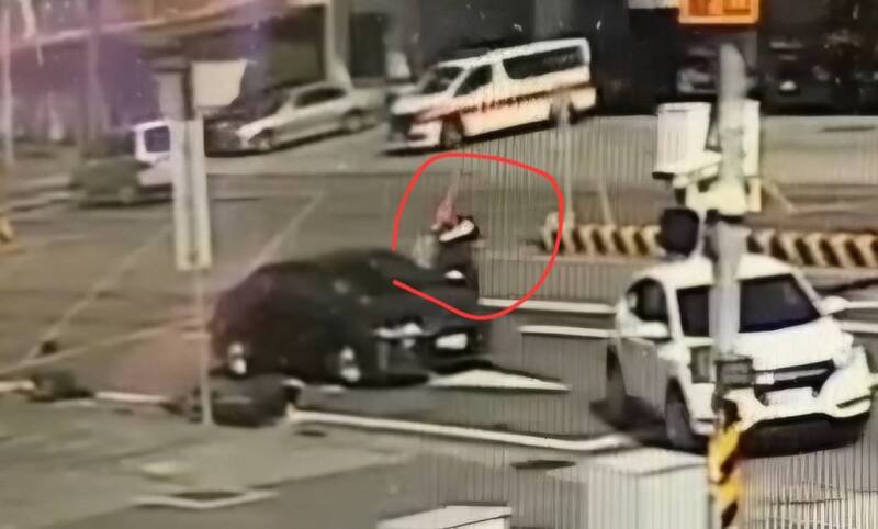 陈翁驾车撞倒李姓骑士后，南投县警察局少年队长邹政达（红圈处）驾白色车挡在其车前，并下车防止陈翁继续开车。（警方提供）