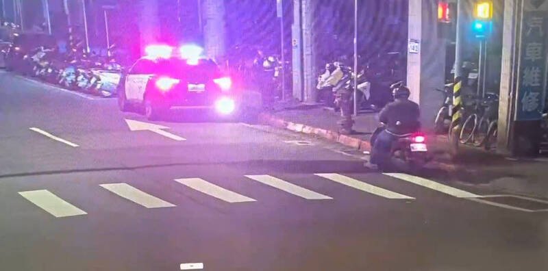 江男骑乘机车在路口右转，见到员警后竟直接停在原地，行径相当可疑。（记者郑景议翻摄）