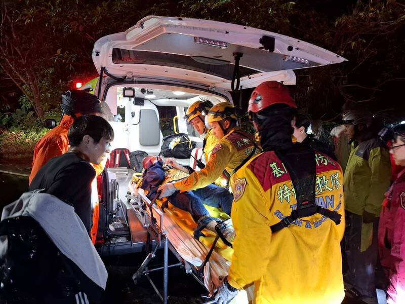 消防队员利用长背板将陈姓妇人救下山，送医急救。（记者林嘉东翻摄）