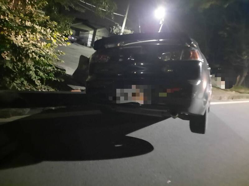 轿车失控撞向路旁卡水沟「翘孤轮」，警方到场不见驾驶。（民众提供）
