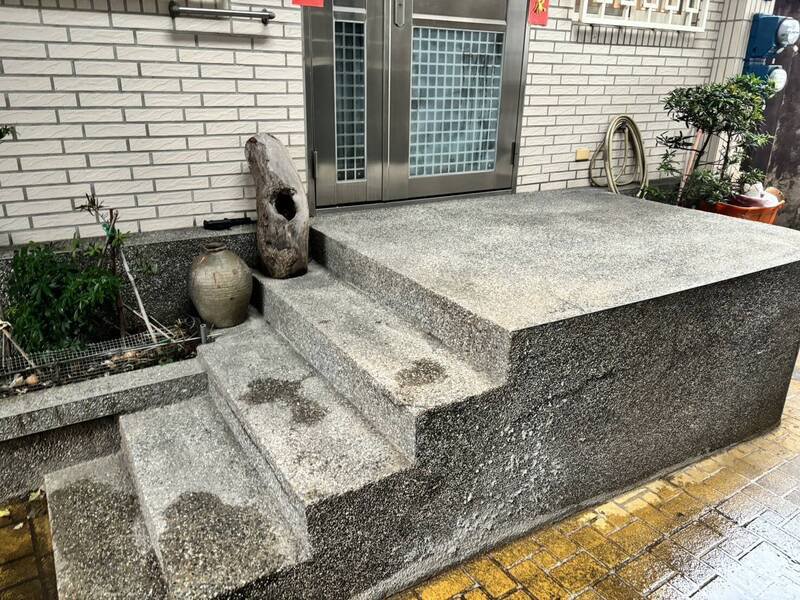 38岁林姓男子今天上午遭人持刀刺入左胸，丢弃路旁；他坐在民宅阶梯前等待消防队员赶抵将他送医急救。（记者林嘉东翻摄）