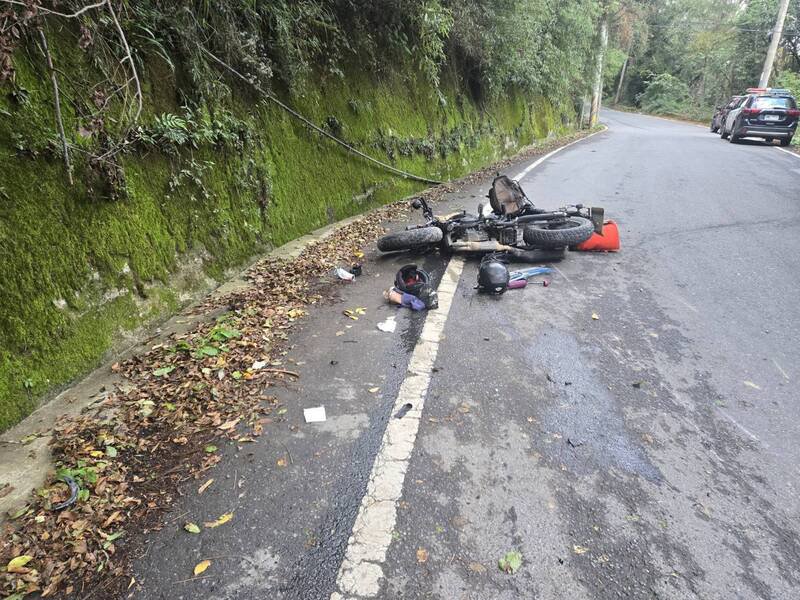重机遭撞后，机车倒在福寿路路肩。（民众提供）