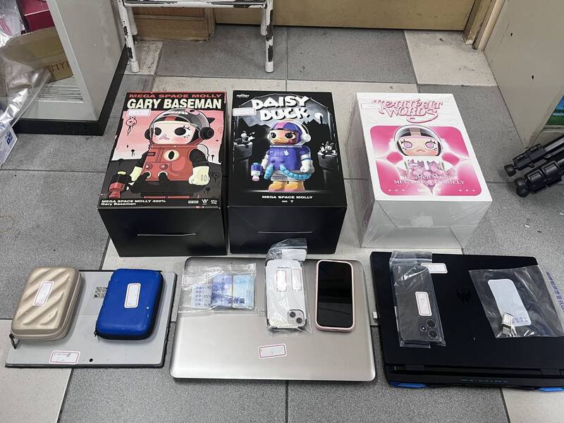 警方查扣笔电、手机、公仔与现金等赃证物。（记者邱俊福翻摄）
