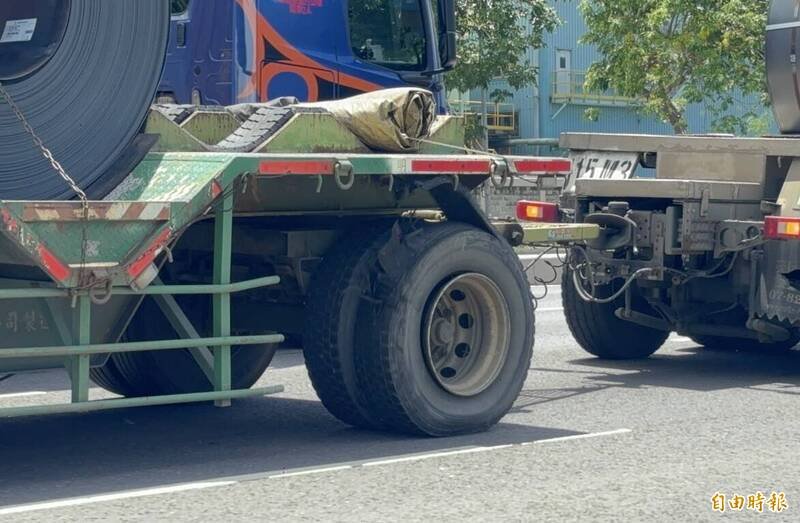 高雄小港一辆载运钢卷拖板车，后轮胎已经严重损坏，但还是依旧行驶在道路上相当危险。（记者李惠洲摄）