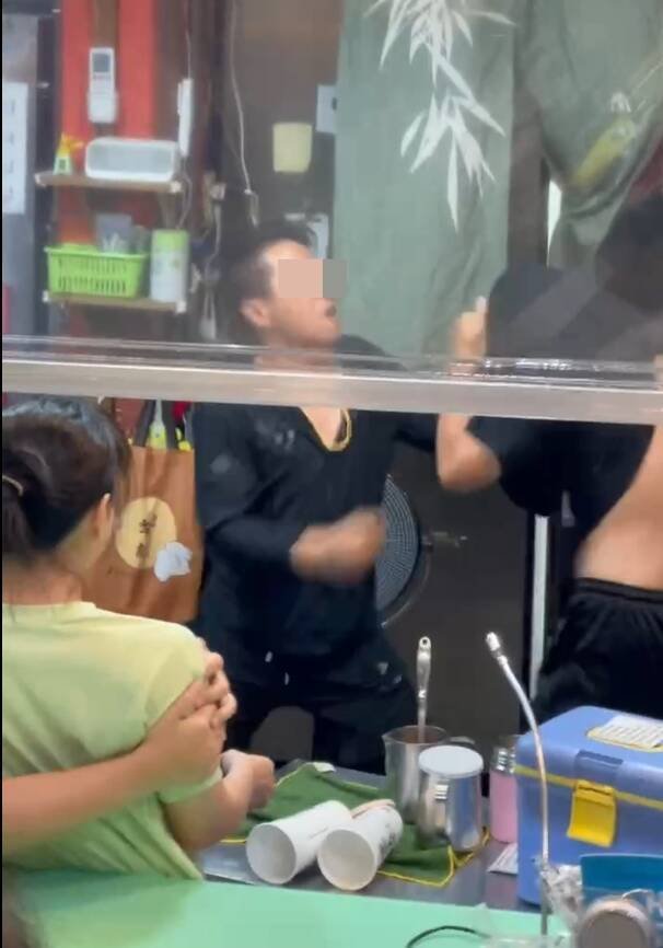 统促党王姓成员骑电动自行车穿梭在永和乐华夜市时，仅因2名少年未听见喇叭声让路，竟朝其中1名少年挥拳殴打，还波及一旁饮料店。（读者提供）
