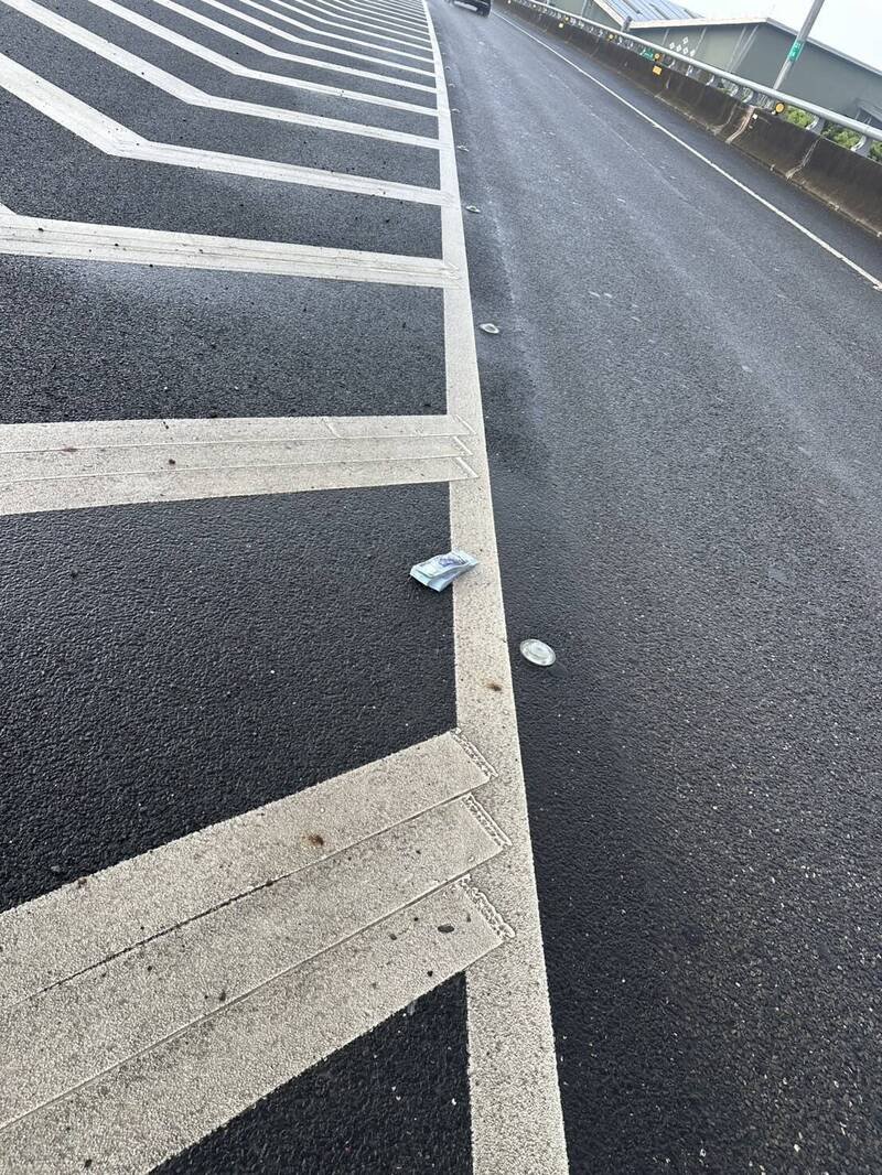 曾男的「两本」钞票就掉在槽化线。（警方提供）