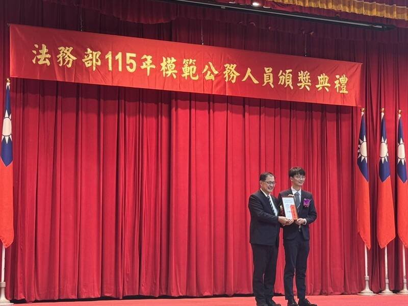 法务部长郑铭谦（左）颁奖表扬获得法务部模范公务人员的台南地检署检察官徐书翰（右）。（台南地检署提供）
