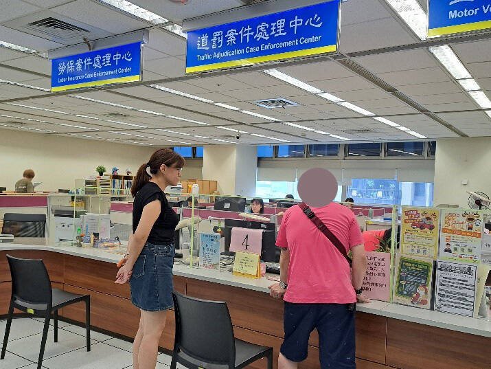 邱男（图右）由书记官（左）陪同至新北市政府交通事件设在新北分署的服务窗口缴纳第1期分期款项。（新北分署提供）