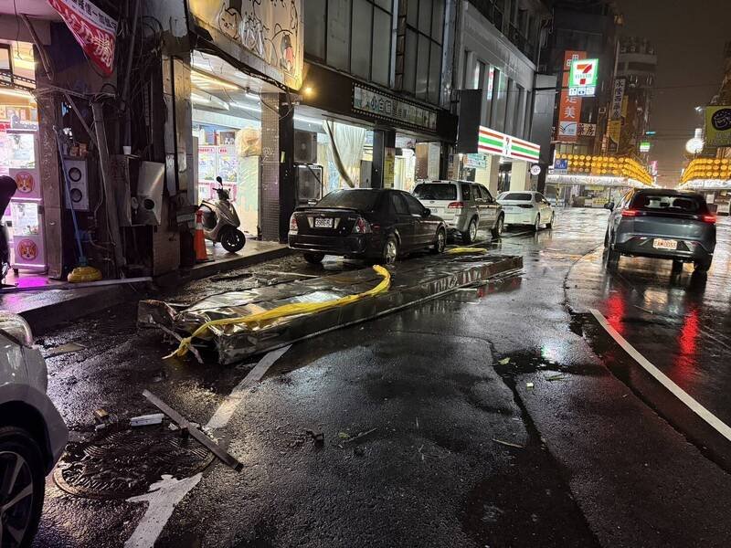 基隆市仁爱区仁三路，邻近基隆庙口一个巨大招牌，遭强风吹落砸中路旁一辆轿车，掉落招牌占据一个车道，影响通行。（警方提供）