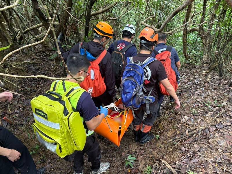 30名山友今天上午结伴登新北市贡寮区卯澳山区，遇到群蜂攻击，1名年约60岁的山友被螫伤后虚弱无力，由消防队以担架救护下山就医。  （记者林嘉东翻摄）