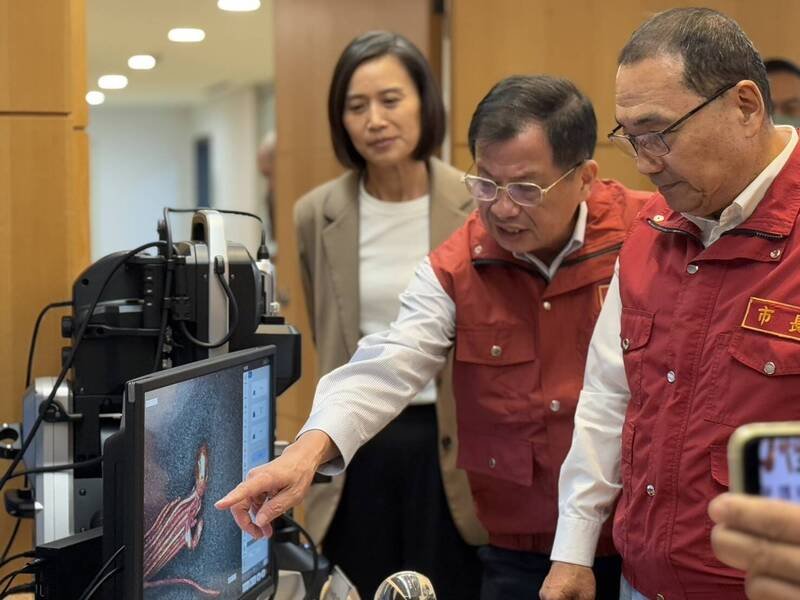 新北市政府今天在市政会议中，由消防局长陈崇岳以「科学鉴识CSI  淬炼韧性新北」为题专案报告，分享新北火调鉴识中心从「科学鉴识」CSI出发，追寻火场真相，进阶以大数据，助攻火灾预防、抢救派遣及城市治理；图为陈崇岳（中）向侯友宜介绍火调器材。（记者吴仁捷翻摄）